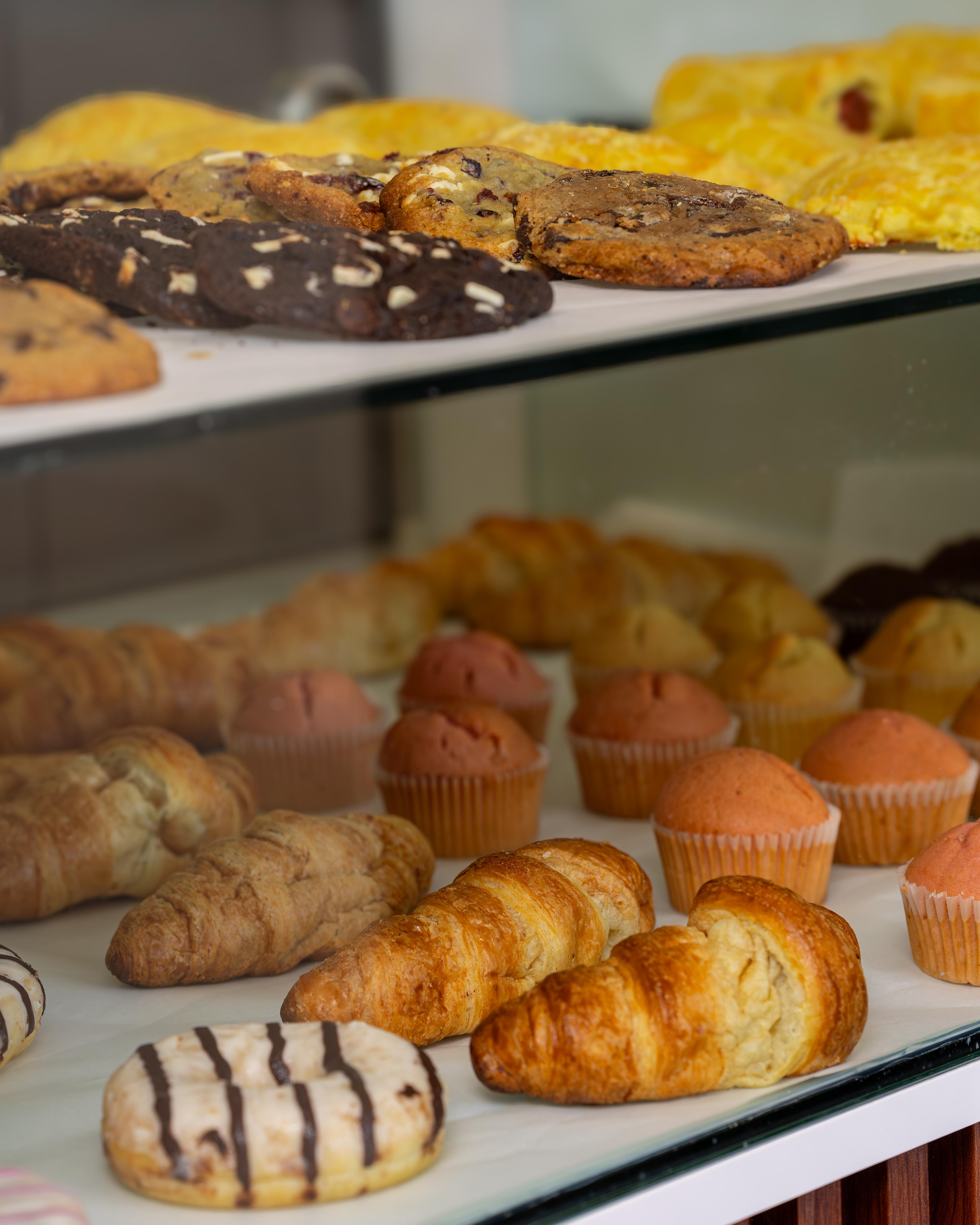 Bakery display with croissants, muffins, and cookies